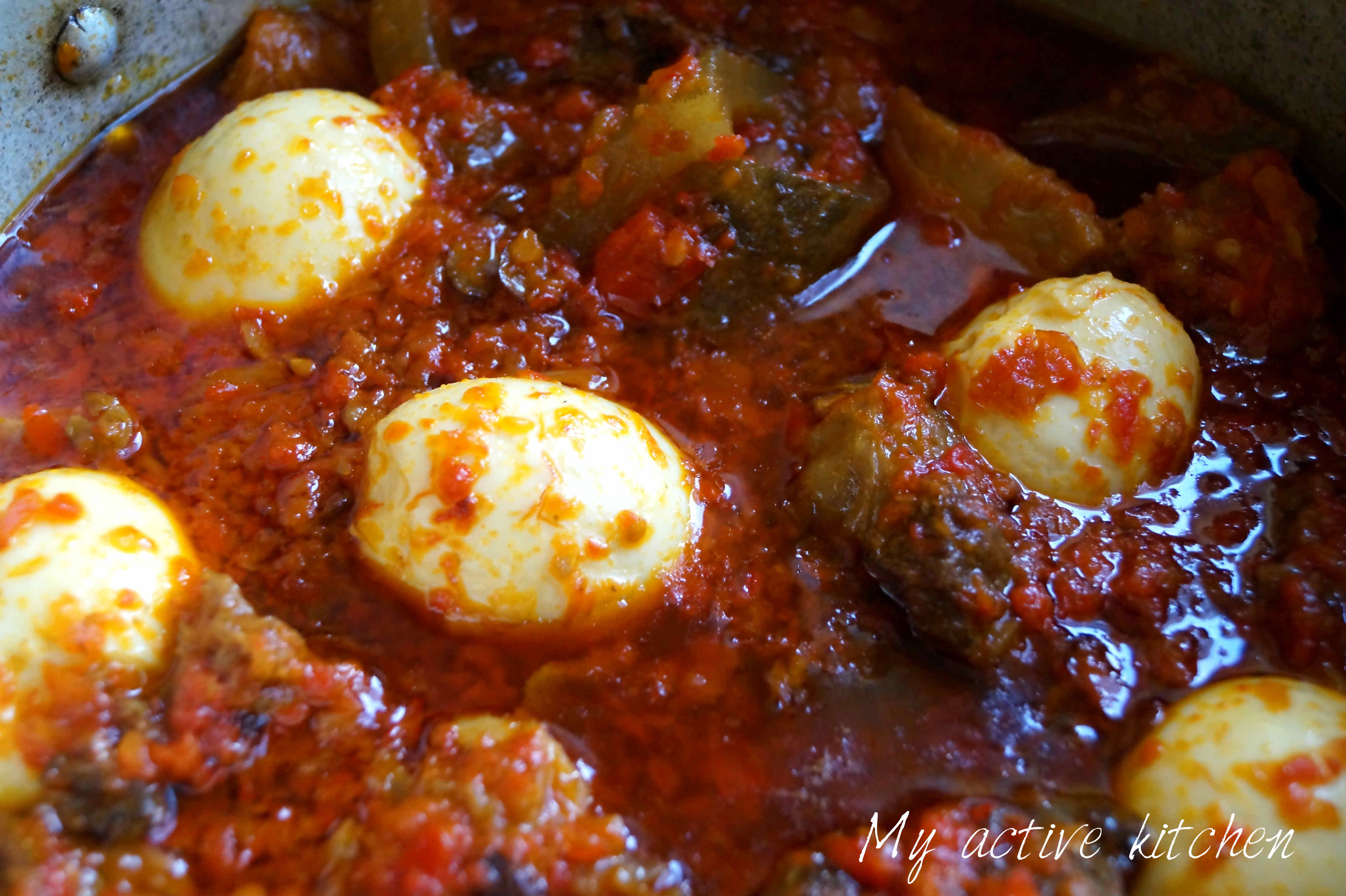 ofada stew with boiled eggs and assorted meat in pot