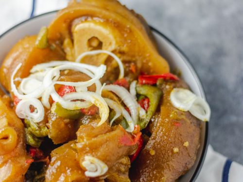 cow leg (cow foot/bokoto)in a black bowl placed on a napkin.