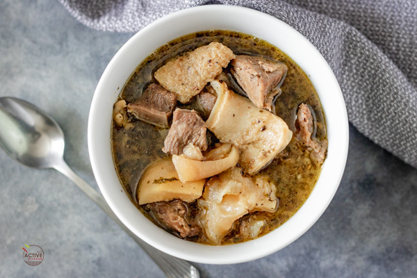 overhead shot of nigerian assorted meat pepper soup in a white bowl.