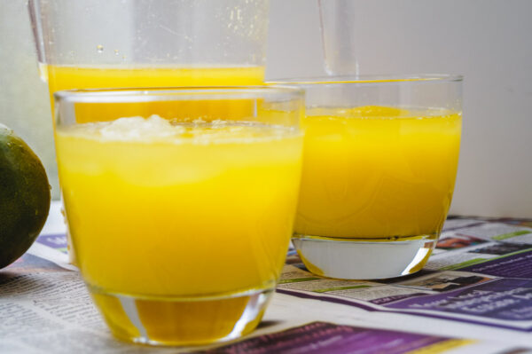 two glasses of mango lemonade on a table