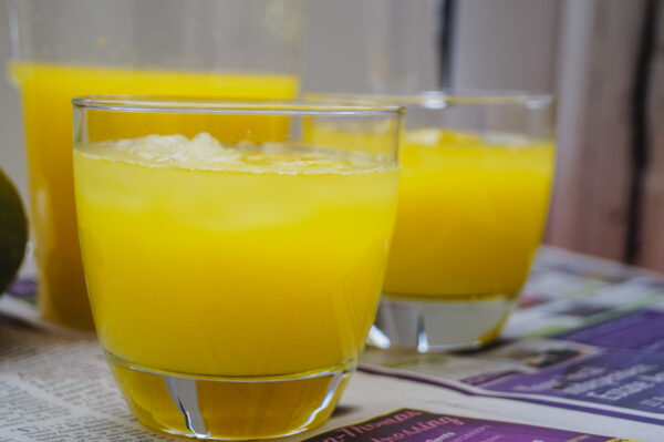two glasses of mango lemonade on a table