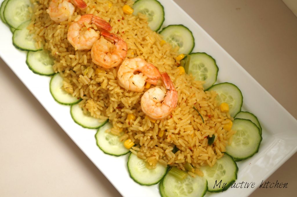 overhead shot of rice and shrimps served on a rectangular white plates.