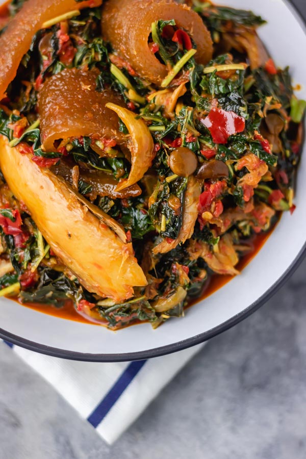 a bowl of efo riro loaded with ponmo and smoked mackerel.