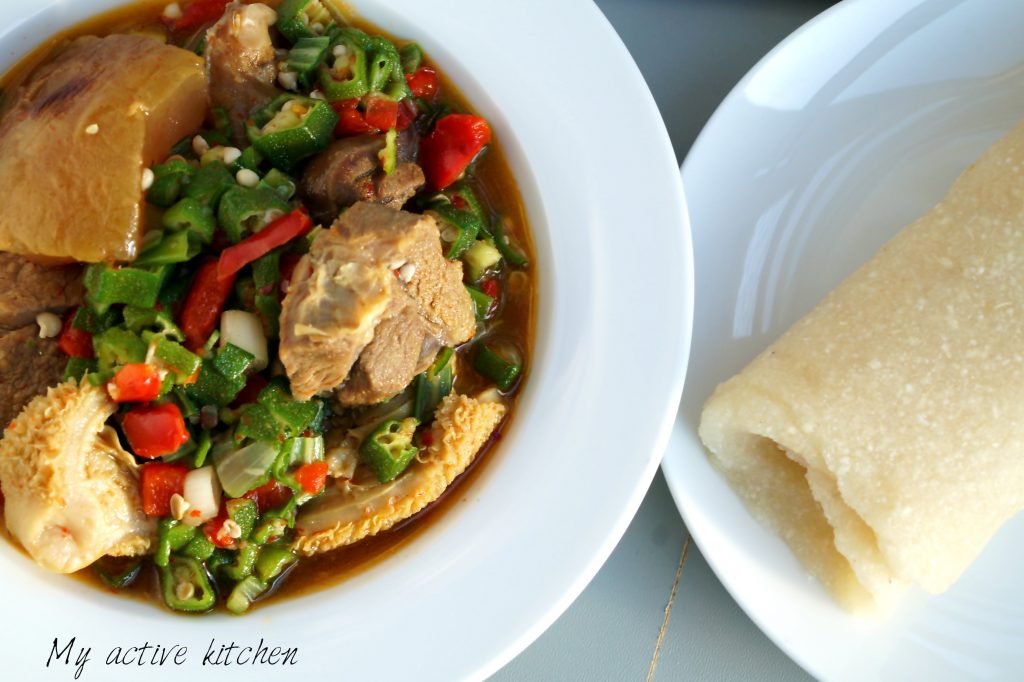 okra soup in a bowl with rolled eba