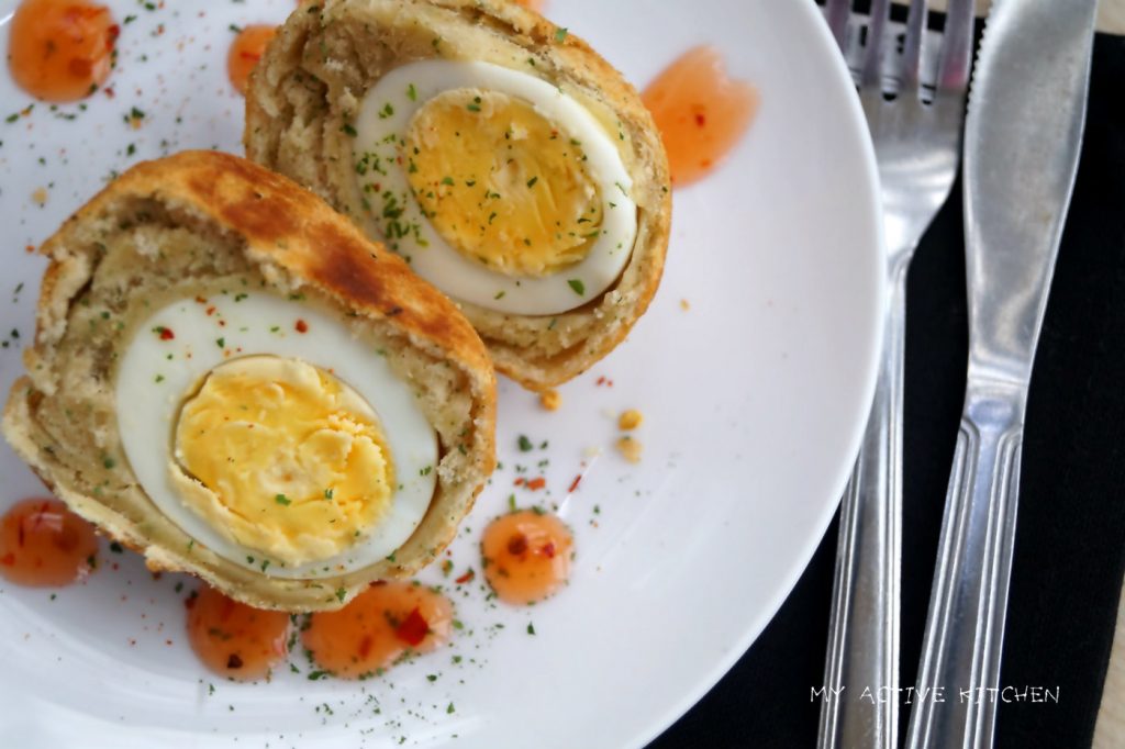 image of Nigerian egg roll cut into halves with sweet chilli sauce on the side