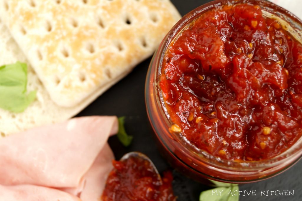 overhead shot of tomato and scotch bonnet jam. ham slices and thin sandwich bread.