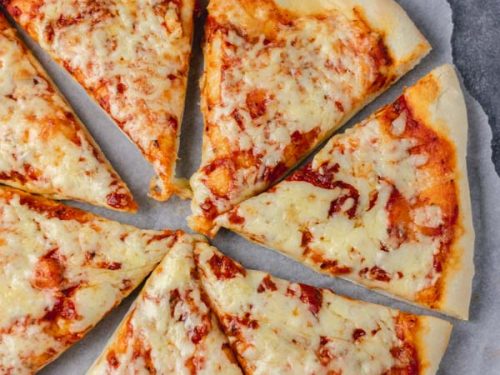 overhead shot of cheese and tomato slices on a parchment paper.