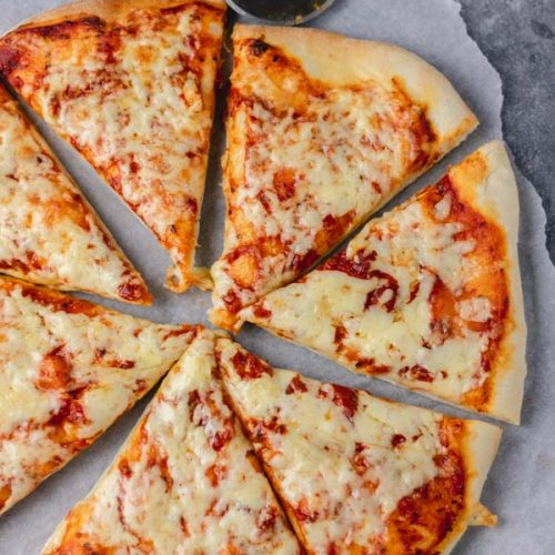 overhead shot of cheese and tomato slices on a parchment paper.