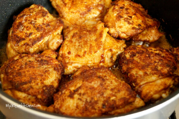 seared spiced chicken in a pan