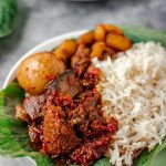 ofada stew with ponmo, assorted meat and egg soaked in stew. It is served with plain boiled rice.