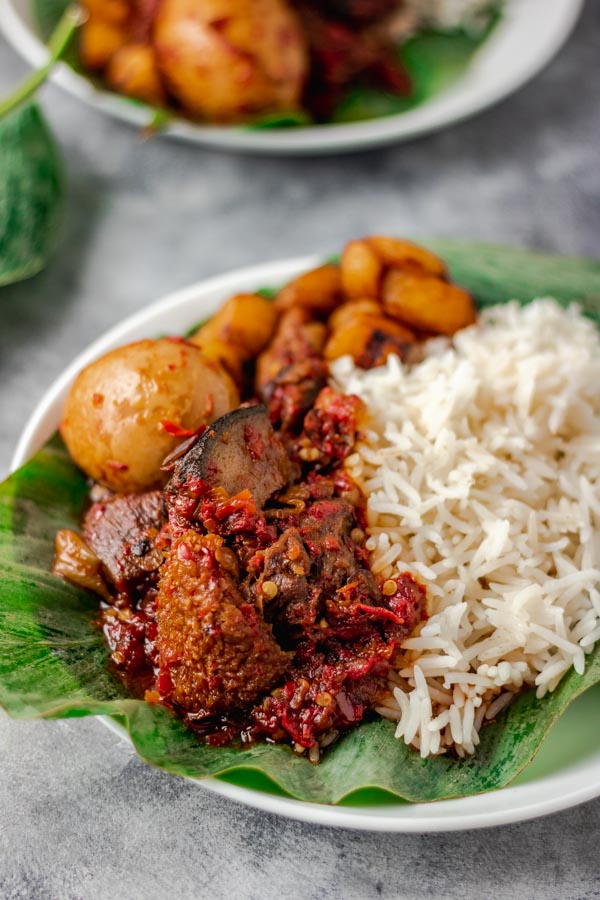ofada stew with ponmo, assorted meat and egg soaked in stew. It is served with plain boiled rice.