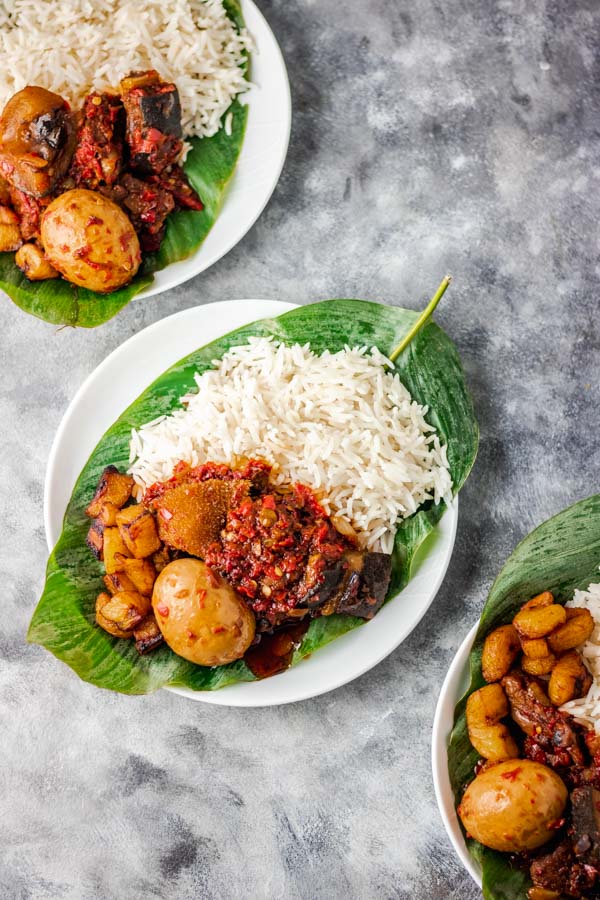 ofada stew and rice served on a banana leaf.