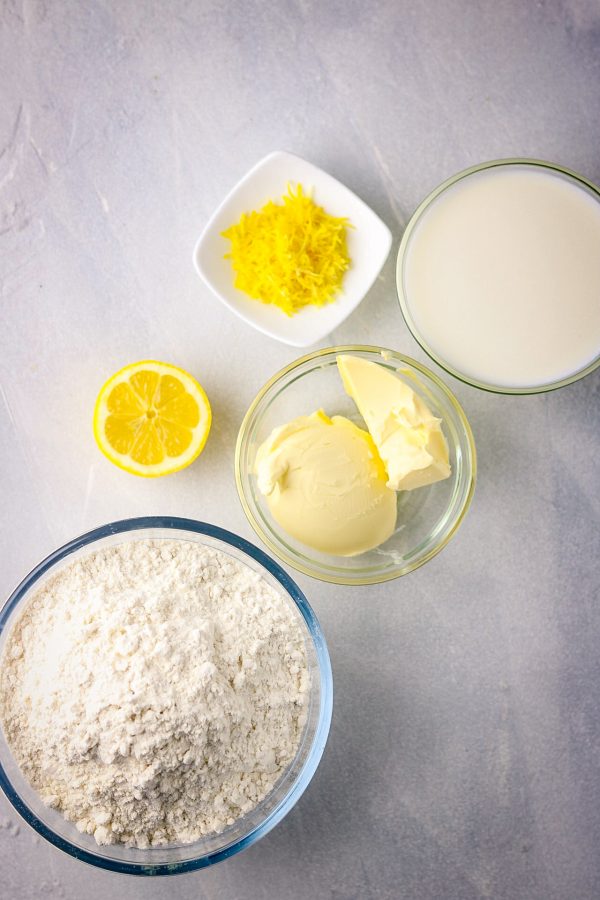 ingredients in bowls, it includes flour, butter,lemon, milk and lemon zest.