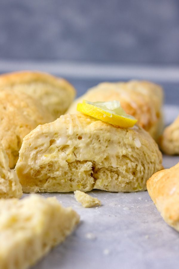 a close shot of lemon scone with a rind of lemon as garnish.