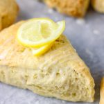 a close shot of triangular scone with a rind of lemon as garnish