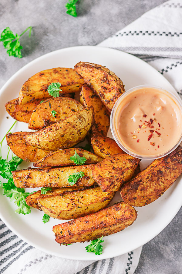 Well seasoned crispy potato wedges!! These crispy potatoes are sinfully good. Not only are they crispy on the outside, they are well seasoned and fluffy on the inside. The best part is they are baked and not fried!!! #easypotatorecipe #potatowedges #healthypotatowedges #healthyfrenchfries 