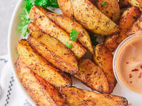 Well seasoned crispy potato wedges!! These crispy potatoes are sinfully good. Not only are they crispy on the outside, they are well seasoned and fluffy on the inside. The best part is they are baked and not fried!!! #easypotatorecipe #potatowedges #healthypotatowedges #healthyfrenchfries