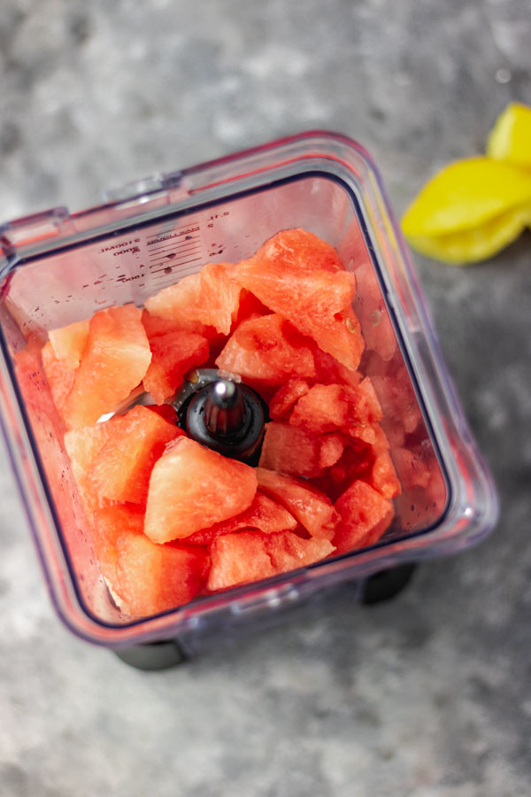 blender filled with fruit to be blended.