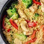 cropped overhead shot of chicken ramen noodle stir fry in a skillet made with broccoli and bell pepper and stir fry sauce.