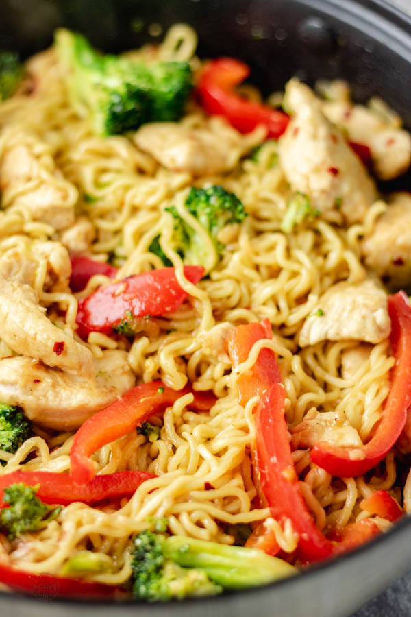 overhead shot of chicken ramen noodle stir fry in a skillet made with broccoli and bell pepper and stir fry sauce.