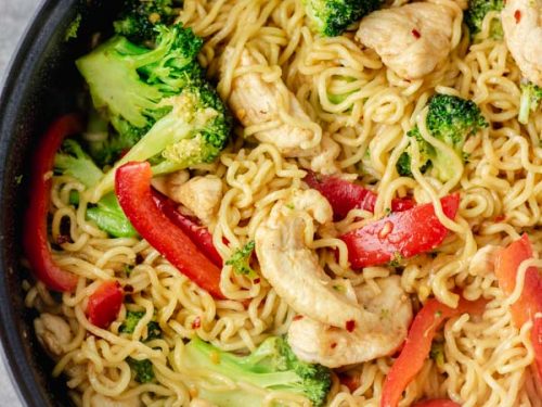 cropped overhead shot of chicken ramen noodle stir fry in a skillet made with broccoli and bell pepper and stir fry sauce.