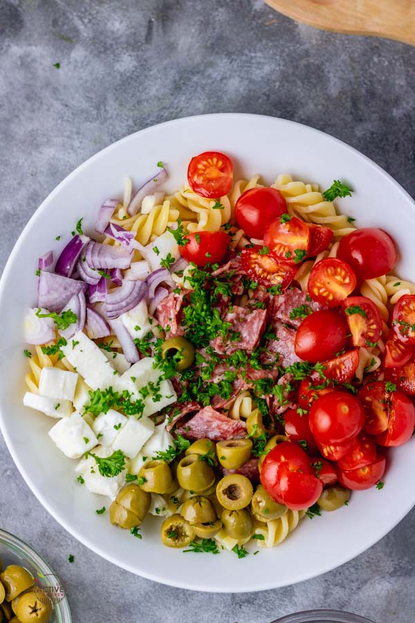 overhead shot of an Italian pasta salad in a white bowl.