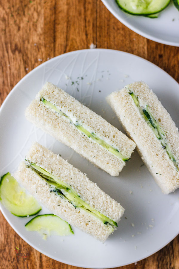 traditional cucumber with cream cheese sandwiches fingers on a white plate.