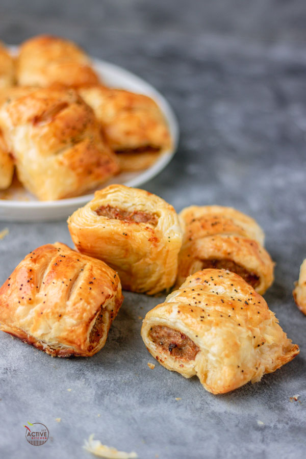Mini sausage rolls on a blue table.