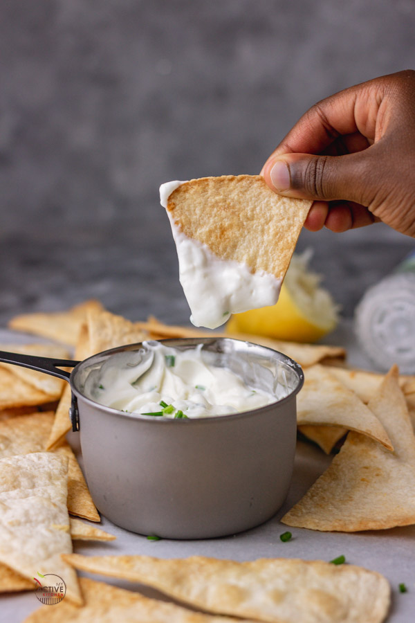 tortilla chips dunked in a sour cream and chive dip