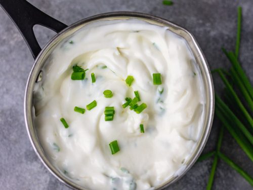 over head shot of sour cream and chive dip. garnished with more chopped chives.