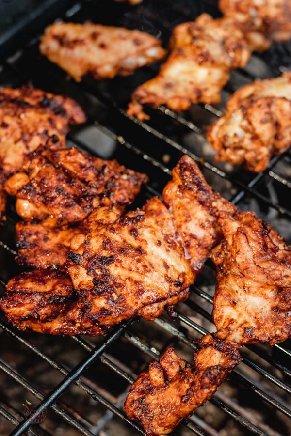 Grilled boneless chicken thigh on a coal barbecue.