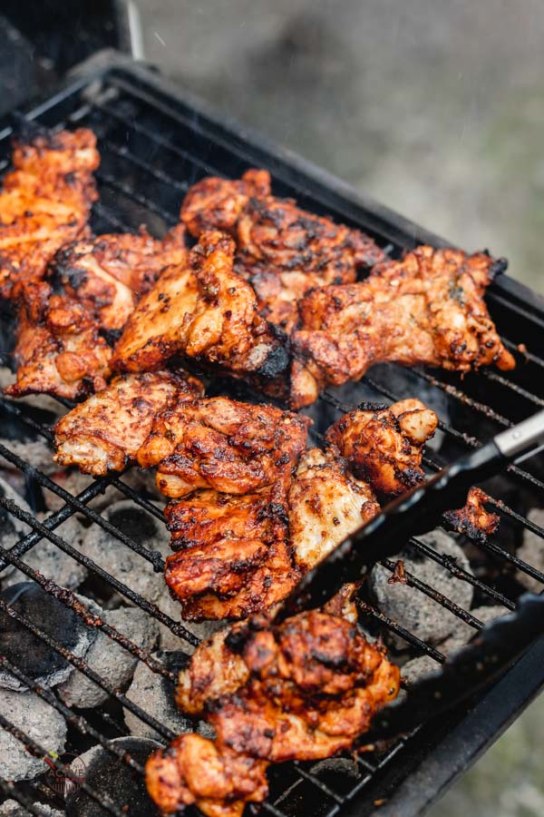 Grilled boneless chicken thigh on a coal barbecue.