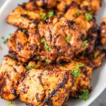 grilled boneless chicken thighs garnished with chopped parsley.