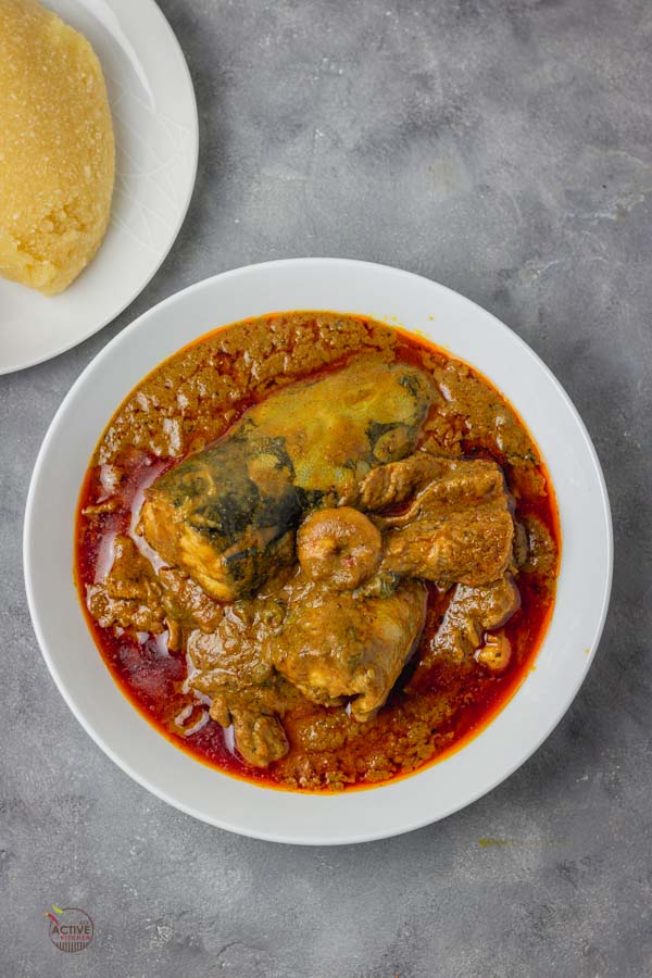 Banga soup cooked with fresh fish, shrimps and periwinkle, it is served with Nigerian eba.