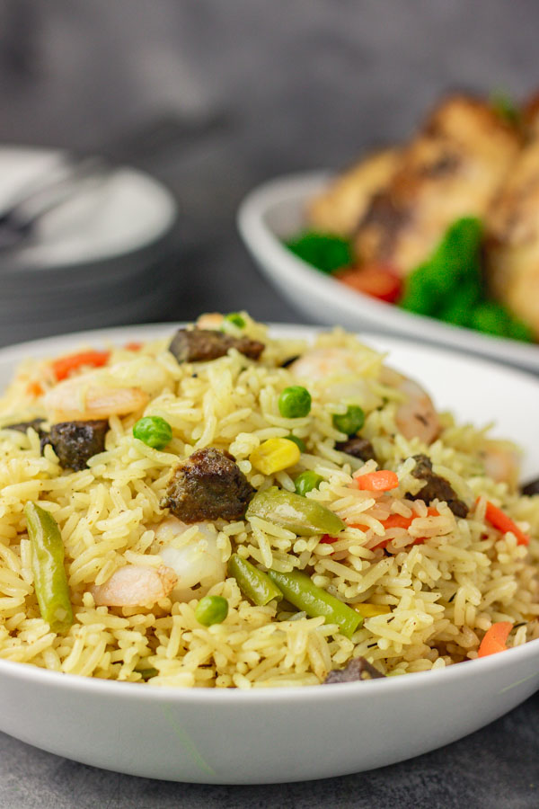 Nigerian fried rice served with a side of chicken thighs.