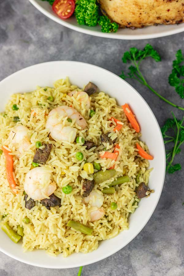 A plate of Nigerian fried rice with prawns and fried liver.