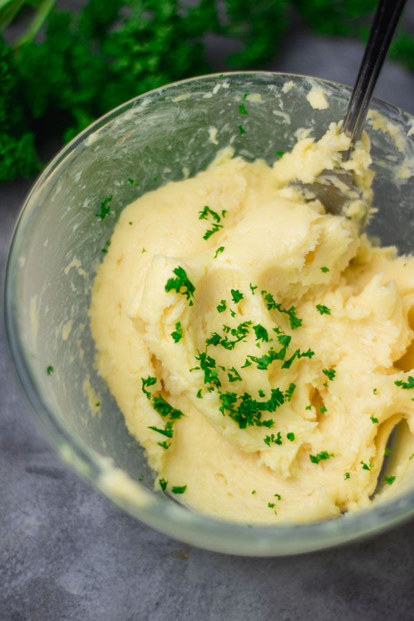 freshly mixed roasted garlic butter with chopped parsley in a bowl.