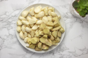 peeled garlic and ginger on a white plate.