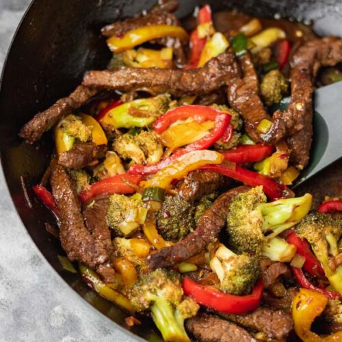 beef and broccoli stir fry in a wok.