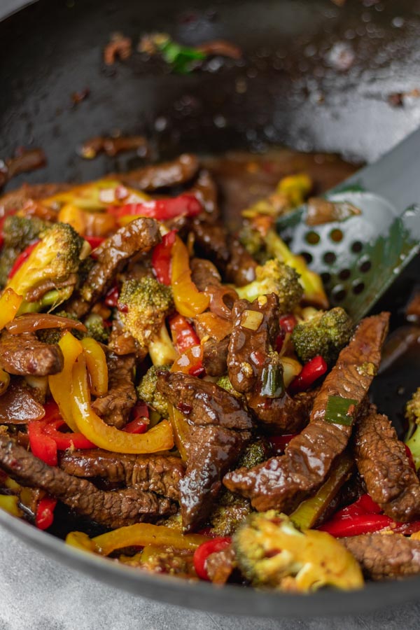 beef stir fry with vegetables in a wok.