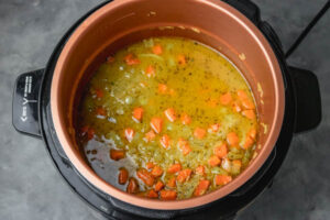 a pot of uncooked rice covered with stock.