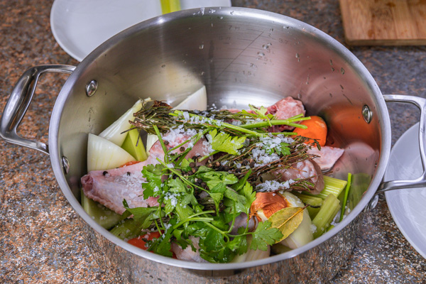 a pot with herbs and chicken.