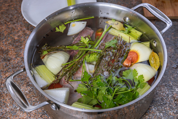 a pot filled with water and herbs.