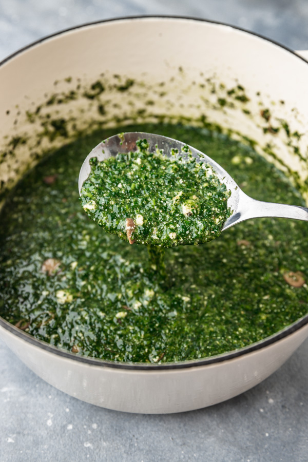 ewedu soup on a ladle over a pot.